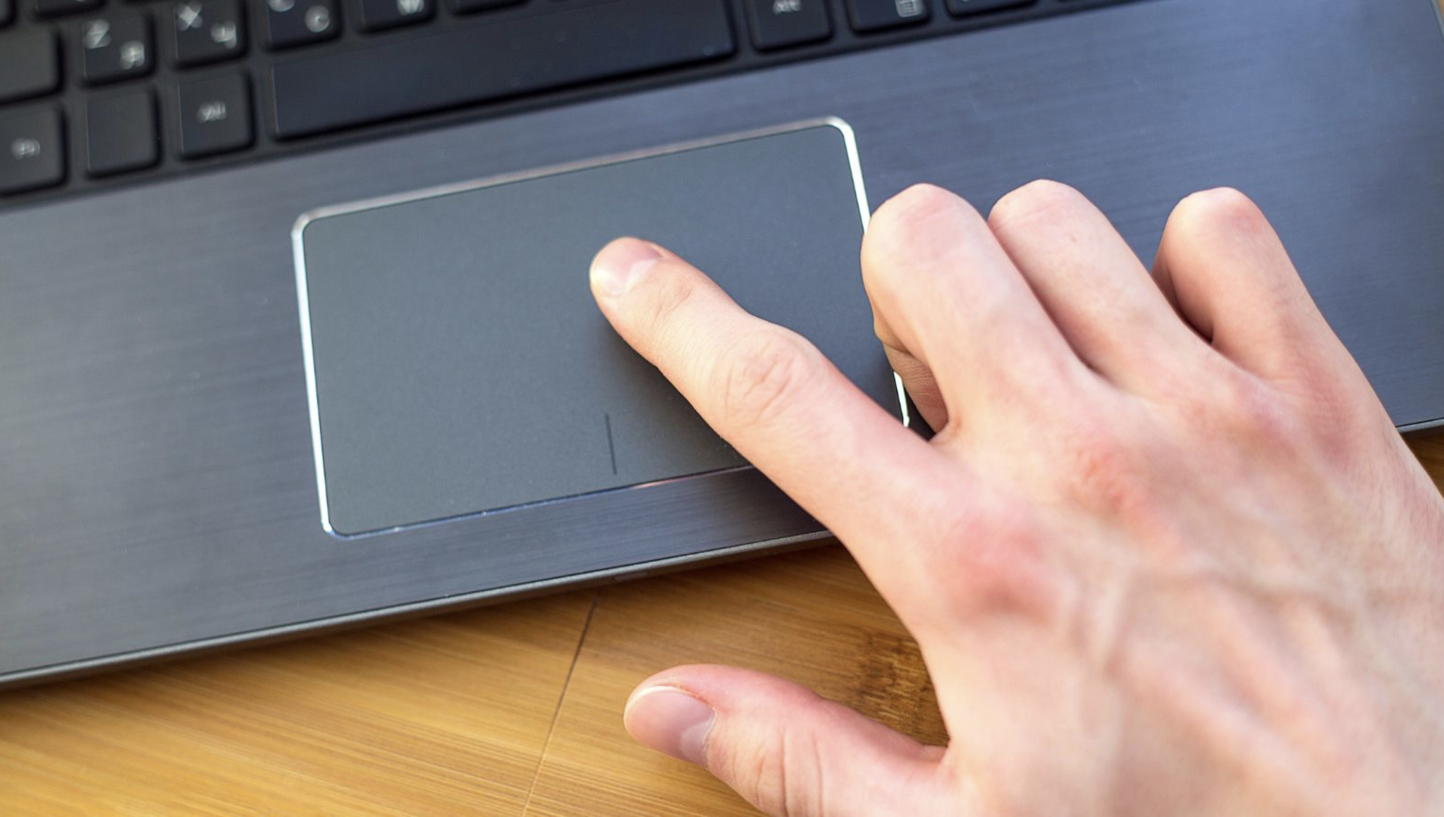 Une main utilisant le trackpad d'un ordinateur portable